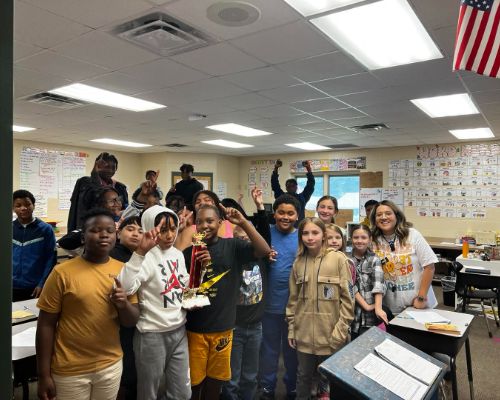  Ms.Montoya's and her 6th grade class holding a trophy for winning the behavioral competition