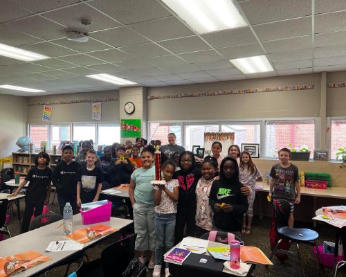  Mrs. Lasagna's 4th grade class holding a trophy for winning the attendance award for the week. 