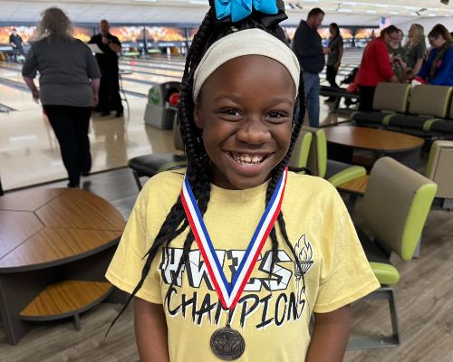  A HWES student posing with her medal from event at Special Olympics. 
