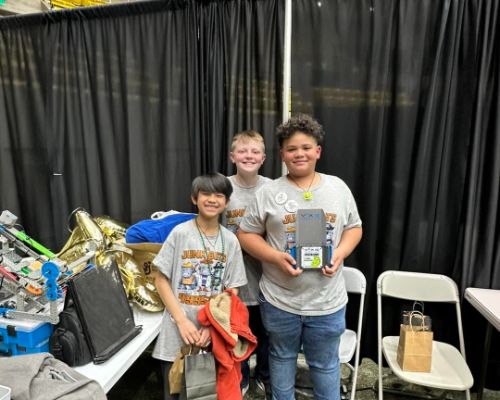  Three robotics team members holding up there award.