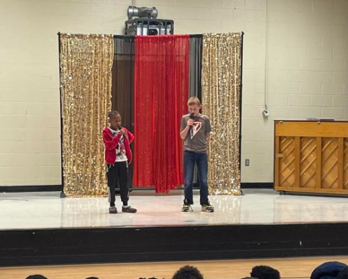  Two students are singing on stage for the talent show.