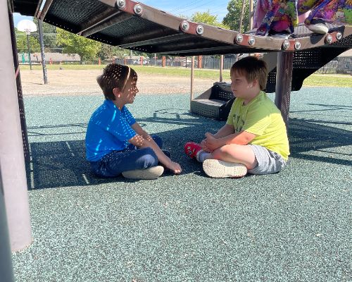  Two HWES students having talk time on the playground