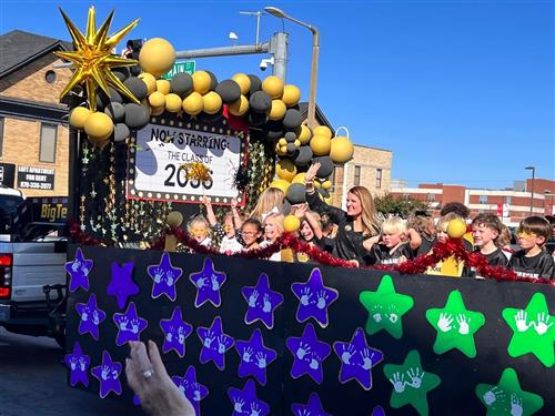 Students riding homecoming float