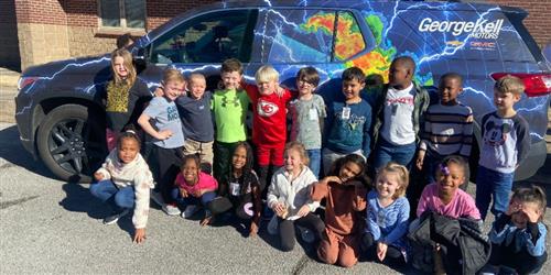 Students next to the storm tracker vehicle.