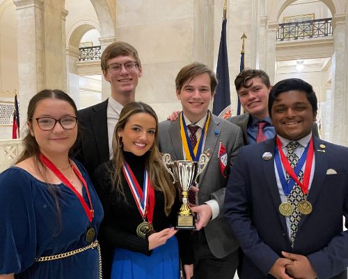  Students smile holding trophy